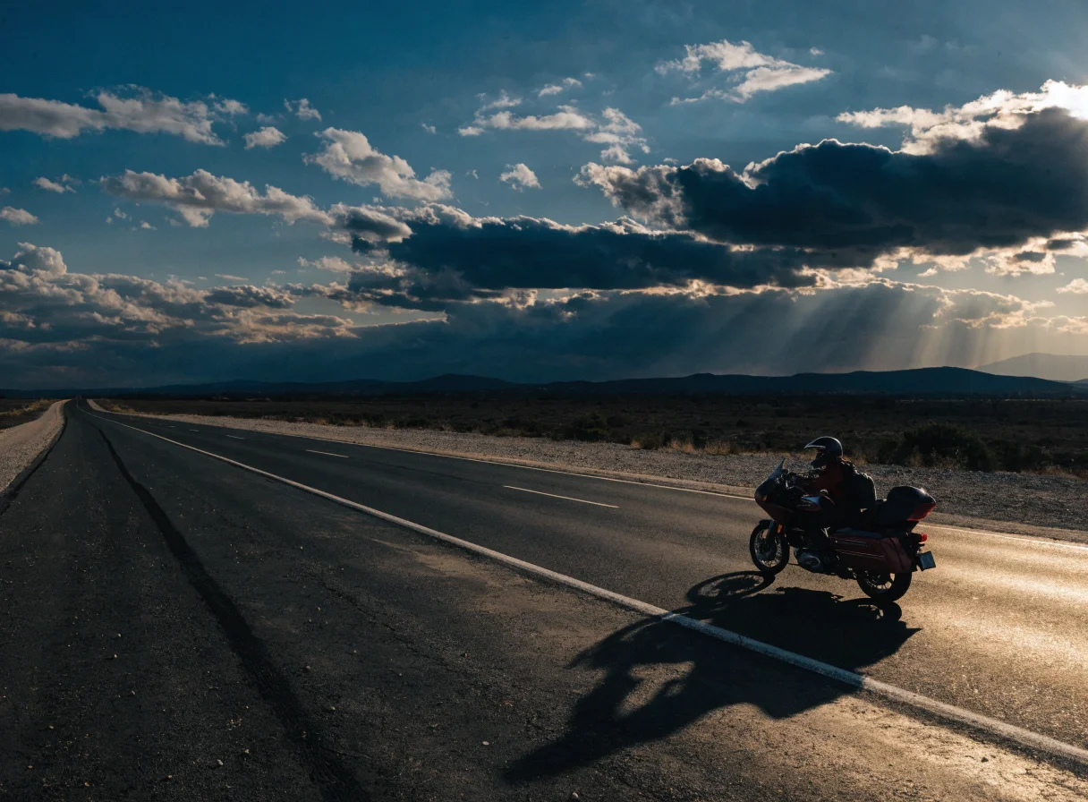 Motard sur une grande route au coucher du soleil